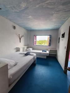 two beds in a room with a window at Casa Violeta Beach House in Rincón +16 photos
