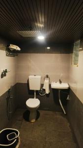 a bathroom with a toilet and a sink at KRS PARADISE premium suite room in Tiruvannāmalai +14 photos