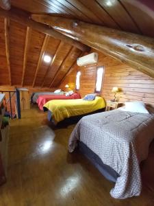 a room with three beds in a log cabin at CABAÑAS ALMA SERENA in Capilla del Monte +12 photos