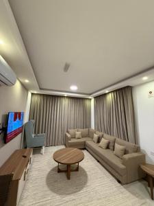 a living room with a couch and a table at Taqah Beach Front Apartment in Ţāqah