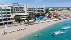 two people in kayaks in the water near a beach at Radisson Blu Hotel & Resort, Sohar in Sohar