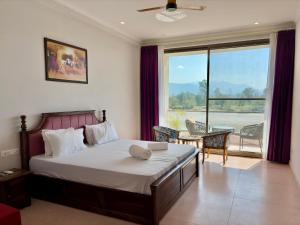 a bedroom with a bed and a large window at Eternal Bliss By Ganga Blessing in Rishīkesh +49 photos