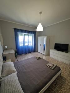 a bedroom with a large bed and a television at La Spiritiera in Minturno