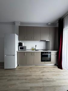 a kitchen with gray cabinets and a white refrigerator at VISAJ Escape in Timişoara