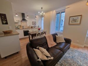 a living room with a couch and a kitchen at Maison de Centre ville in Limoux