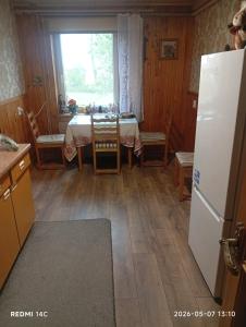 a kitchen with a table and a refrigerator at Sodyba Skardupiai in Vidgiriai