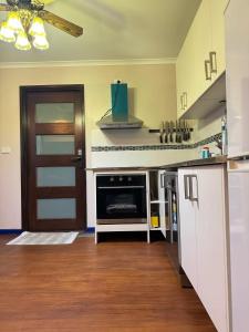 a kitchen with a stove and a door in a room at Sweet home in Goodwin Hill in Macgregor