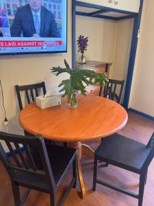 a wooden table with chairs and a vase with a plant on it at Sweet home in Goodwin Hill in Macgregor +7 photos