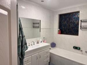 a bathroom with a sink and a tub and a mirror at Sweet home in Goodwin Hill in Macgregor