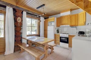 a kitchen with wooden cabinets and a wooden table at ÄkäsLuppo - Valkea Homes in Kittilä +19 photos