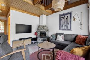 a living room with a couch and a fireplace at ÄkäsLuppo - Valkea Homes in Kittilä