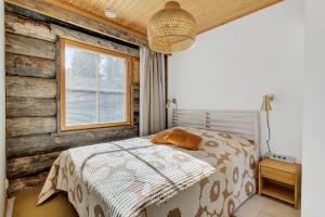 a bedroom with a bed and a wooden wall at ÄkäsLuppo - Valkea Homes in Kittilä