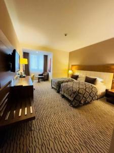 a hotel room with a bed and a desk at Crixus Hotels Duhok in Duhok