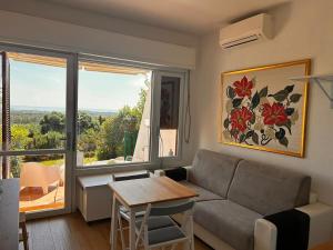 a living room with a couch and a table and a window at Bilocale Is Molas Design, Giardino e Relax in Is Molas 