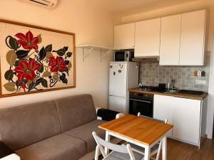 a kitchen and a living room with a couch and a table at Bilocale Is Molas Design, Giardino e Relax in Is Molas  +6 photos