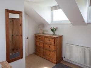 a attic room with a dresser and a window at Hayloft - Ukc4678 in Clynnog-fawr