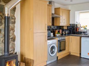 a kitchen with a stove and a washer and dryer at Hayloft - Ukc4678 in Clynnog-fawr