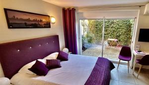 a bedroom with a bed with purple pillows and a window at Villa Etoile in Cannes