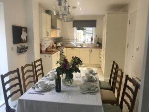 a dining room table with a white table cloth and flowers at Clock Tower Cottage in Whitchurch