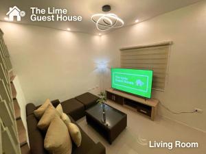 a living room with a couch and a flat screen tv at The Lime Guesthouse in Angeles