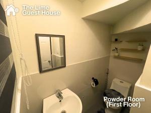 a bathroom with a toilet and a sink and a mirror at The Lime Guesthouse in Angeles