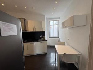 a kitchen with white cabinets and a table with chairs at Luxe Apartment am Rhein in Worms