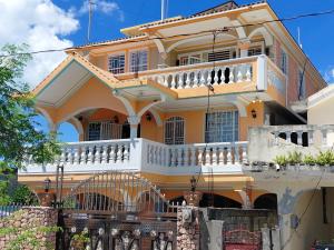 a large yellow house with a balcony at Villa Simon Guest house in Les Cayes +11 photos