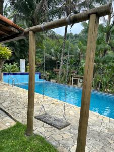 a swing in front of a swimming pool at Pousada céu azul Paraty in Paraty +12 photos