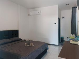 a bedroom with a bed and a table at Home No 3 khanom in Ban Thung O