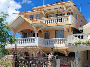 a large yellow house with a balcony at Villa Simon Guest house in Les Cayes