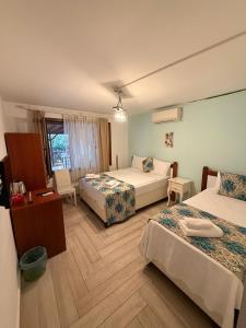 a hotel room with two beds and a table and chairs at Ceren pansiyon in Seferihisar