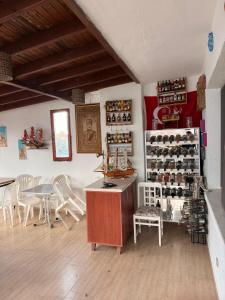 a room with a table and chairs and a shelf of wine bottles at Ceren pansiyon in Seferihisar