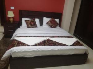a bedroom with a large bed with white sheets and pillows at فندق دير البتراء السياحي in Wadi Musa