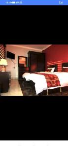 a bedroom with a large bed with a red wall at فندق دير البتراء السياحي in Wadi Musa