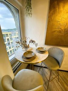 a table and two chairs in a room with a window at Zentrales Design Loft über den Dächern St Gallens in St. Gallen