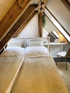 two beds in a room with an attic at Zentrales Design Loft über den Dächern St Gallens in St. Gallen