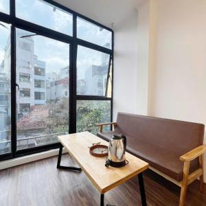 a room with a coffee table and a large window at Hanowood Homestay - Renovated since June 2026 in Hanoi