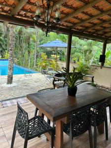 a wooden table with chairs and a potted plant on a patio at Pousada céu azul Paraty in Paraty