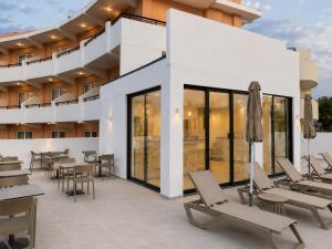 Sandora Living في فاليراكي: فناء به طاولات وكراسي ومبنى