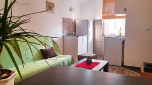een woonkamer met een groene bank en een tafel bij Apartments Mila Tivat in Tivat