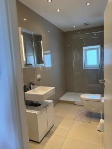 a bathroom with two sinks and a toilet and a shower at Luxe Apartment am Rhein in Worms +19 photos