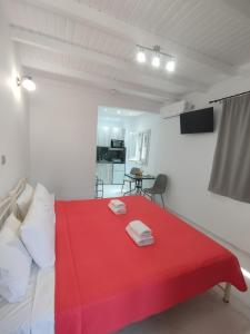 a room with a red bed with a red blanket at Manganas Studios in Paleokastritsa