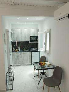 a kitchen with a table and chairs in a room at Manganas Studios in Paleokastritsa