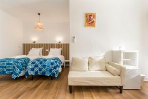 a hotel room with two beds and a couch at Learn Fun Madalena - Shared Swimming pool in Madalena +10 photos