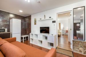 a living room with a couch and a tv at Learn Fun Madalena - Shared Swimming pool in Madalena