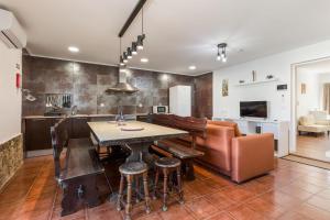 a kitchen and living room with a table and a couch at Learn Fun Madalena - Shared Swimming pool in Madalena
