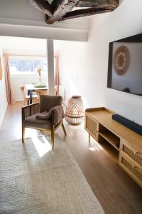 a living room with a couch and a tv at Le Grand Rue Signature - Appartement coeur de ville, rue piétonne in Bergerac