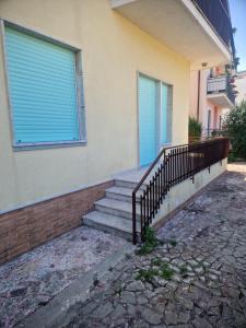 a house with stairs and a window with blue shutters at La Spiritiera in Minturno