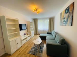 a living room with a couch and a tv at Zen Flat - 5 min Metrou in Bucharest