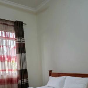 a bedroom with a bed and a window at Kilimanjaro Magic MJ Branch in Old Moshi